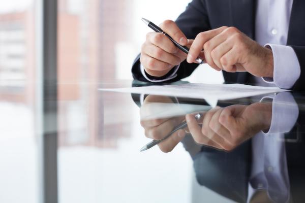 Businessman holding a pen over a document